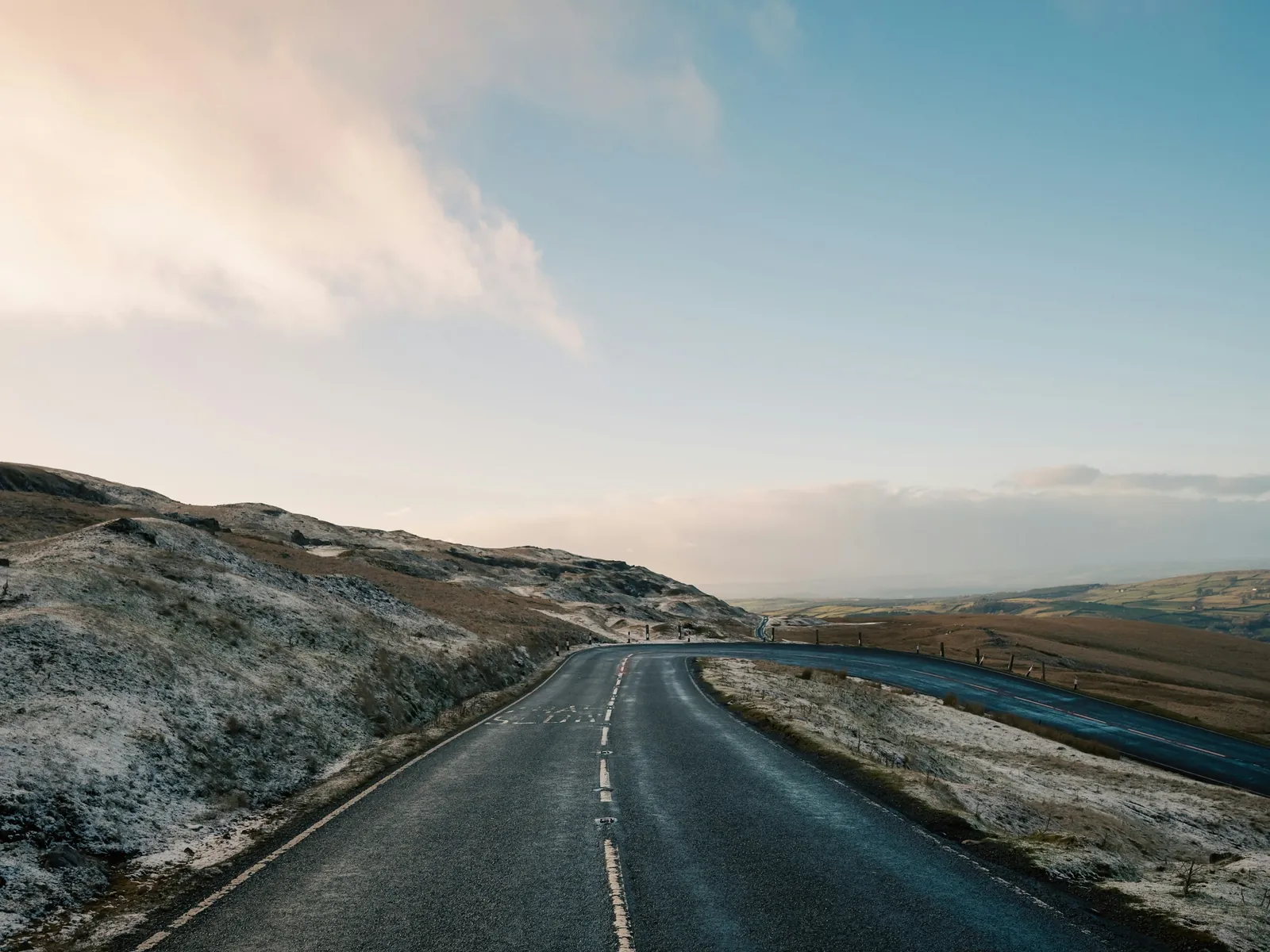 A quiet road leading forward through an open landscape
